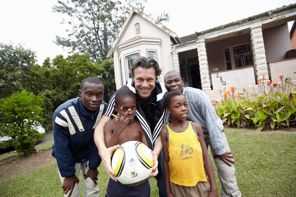 Urs Meier mit Kindern und einem Fussball in Brasilien